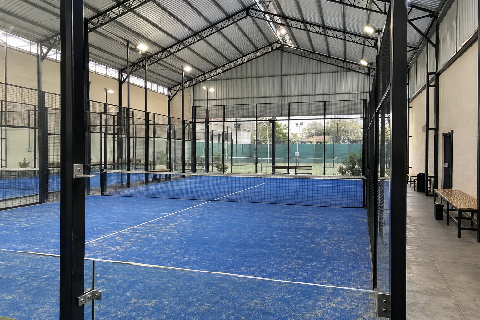 Canchas de pádel techadas de Pádel Norte, con césped azul y estructura negra